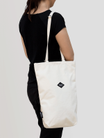 A model wearing the white Braasi Canvas Bag over her shoulder