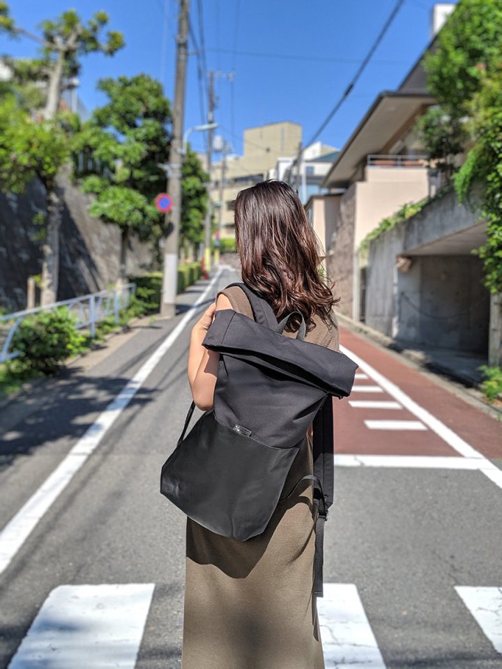 Model wearing Braasi Ayo backpack made out of black cotton canvas and black Italian leather.