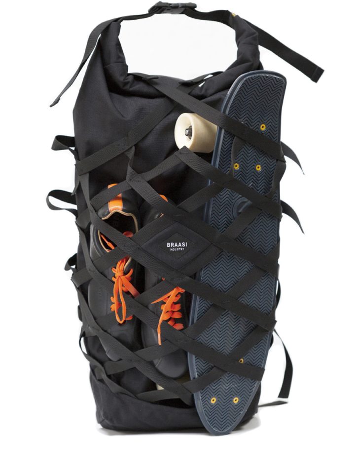 The black EVO II Braasi backpack storing a penny board and sneakers behind its webbing