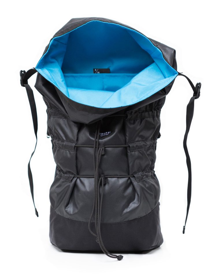 The black Mika Braasi backpack showing its blue inner lining and practical inside pockets