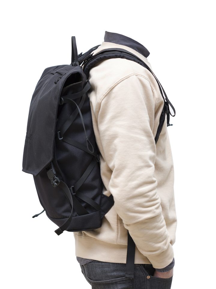 A man wearing the Braasi Klopista, a practical designer backpack great for travel.