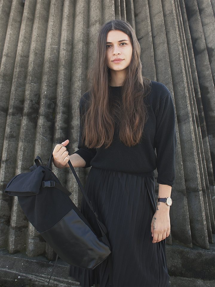 Model holding the Braasi Ayo Black, a stylish backpack with a minimalist design made in Europe.
