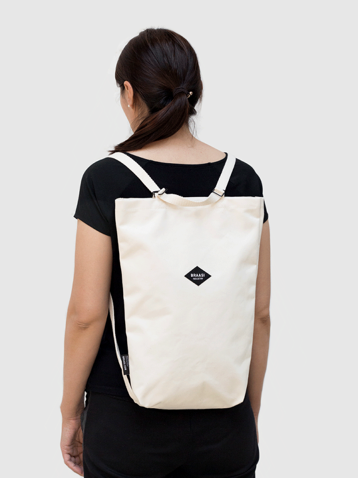 A model wearing the white Canvas Bag backpack from Braasi on her back